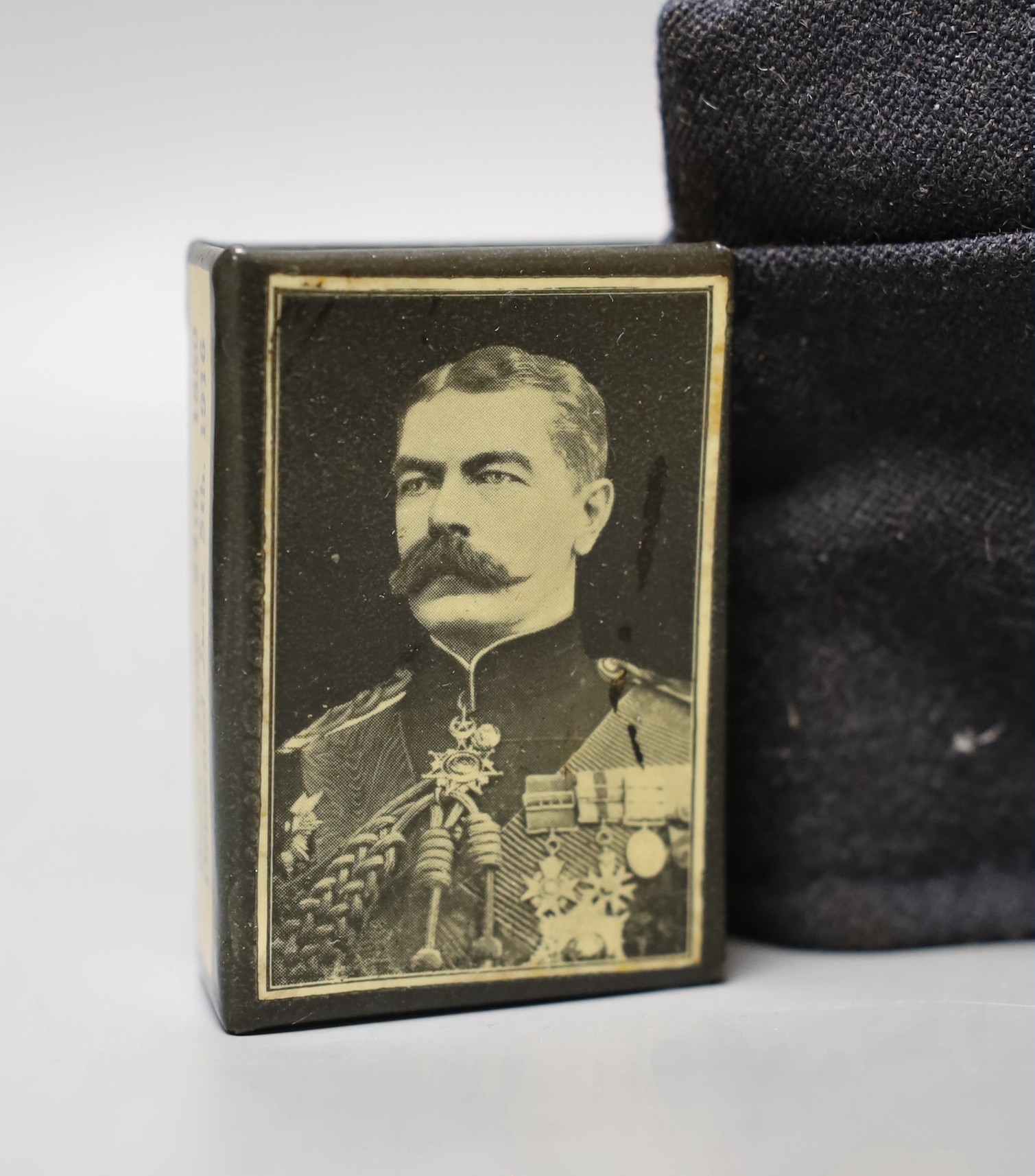 An Airforce cap. a Kitchener commemorative matchboc, a WWI uniform repair kit and a bincoluar lens cleaning kit